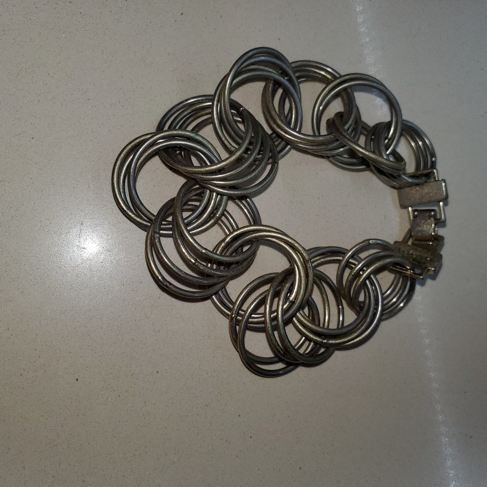 VINTAGE BRACELET DONE IN INTERTWINING METAL CIRCLES.